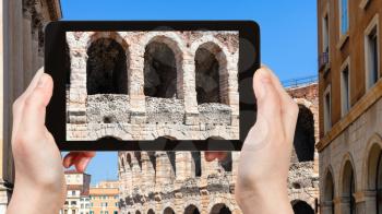 travel concept - tourist photographs wall of Arena di Verona ancient Roman Amphitheatre in Verona city in Italy on tablet