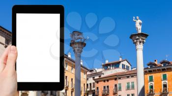 travel concept - tourist photographs statues on tops of columns at Piazza dei Signori in Vicenza city in spring on tablet with cut out screen for advertising logo