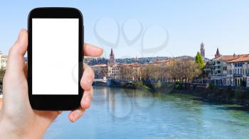 travel concept - tourist photographs Verona city on Adige river in spring on smartphone with cut out screen for advertising logo