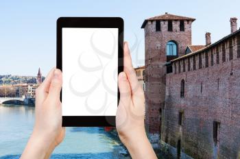 travel concept - tourist photographs cityscape with castel vecchio castle and Adige river in Verona city in spring on tablet with cut out screen for advertising logo
