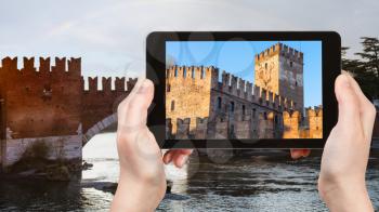 travel concept - tourist photographs Castelvecchio (Scaliger) Castel in Verona city in Italy in spring evening on tablet