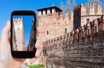 travel concept - tourist photographs walls of Castelvecchio (Scaliger) Castel in Verona city in Italy on smartphone
