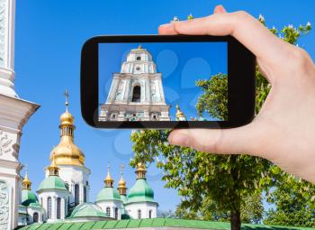 travel concept - tourist photographs bell tower of Saint Sophia Cathedral in Kiev city in Ukraine on smartphone
