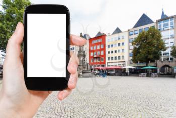 travel concept - tourist photographs Old Market (Alter Markt) square in Cologne city in Germany in september on smartphone with cut out screen for advertising logo