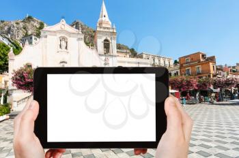 travel concept - tourist photographs piazza 9 aprile in Taormina city in Sicily Italy in summer season on tablet with cut out screen for advertising logo