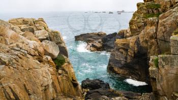 travel in France - view of rocks on shore of Gouffre gulf of English Channel near Plougrescant town of the Cotes-d'Armor department in Brittany in summer rainy day