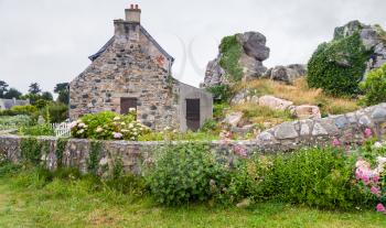 travel in France - typical stone Breton house with garden in Plougrescant town of the Cotes-d'Armor department in Brittany in rainy summer day