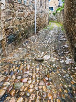 travel to France - wet pavement of narrow street in Treguier town in the Cotes-d'Armor department of Brittany in summer rainy day