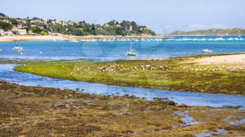 travel to France - view of Perros-Guirec town through estuary of river Kerduel and bay Anse de Perros in Cotes-d'Armor department in the north of Brittany in sunny summer day