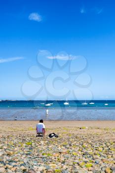 travel to France - man on beach Plage de la Baie de Launay on bay Anse de Launay of English Channel in Paimpol region of Cotes-d'Armor department of Brittany in sunny summer day