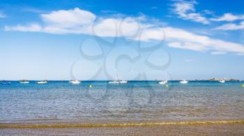 travel to France - boats near beach Plage de la Baie de Launay on bay Anse de Launay of English Channel in Paimpol region of Cotes-d'Armor department of Brittany in sunny summer day