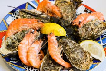 travel to France - atlantic seafood plate with prawns and oysters in local fish restaurant in Treguier town in the Cotes-d'Armor department of Brittany