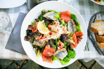 travel to France - top view of plate with big salad with fish in outdoor cafe in Strasbourg city in Alsace region