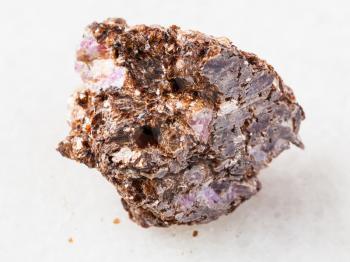 macro shooting of natural mineral rock specimen - rough Phlogopite stone with corundum crystal on white marble background from Tajikistan