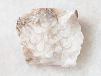 macro shooting of natural mineral rock specimen - raw Anhydrite stone on white marble background