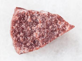 macro shooting of natural mineral rock specimen - raw pink Quartzite stone on white marble background