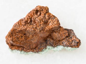 macro shooting of natural mineral rock specimen - raw bog iron ore ( limonite) stone on white marble background from Taman Peninsula, Russia