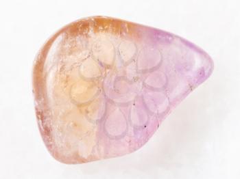 macro shooting of natural mineral rock specimen - polished Ametrine gemstone on white marble background from Brazil