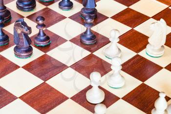 chess gameplay on wooden chessboard close up
