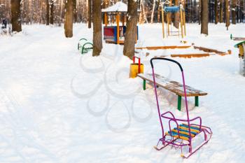 snow-covered playground in urban park in winter twilight