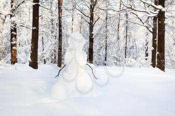 snowman on snow glade in Timiryazevskiy forest park of Moscow city in sunny winter morning
