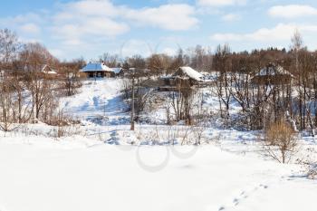 snow-covered little russian village in sunny winter day in Smolensk region of Russia