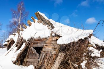 ruins of abandoned rural house in sunny winter day in little village in Smolensk region of Russia