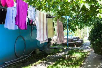 clothes drying on ropes at backyard of country house in sunny summer day in Kuban region of Russia