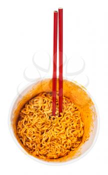top view of red chopsticks in cup with cooked spicy instant noodles isolated on white background