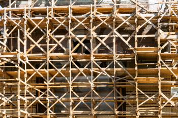 wooden scaffolds on multi-storey building in summer day