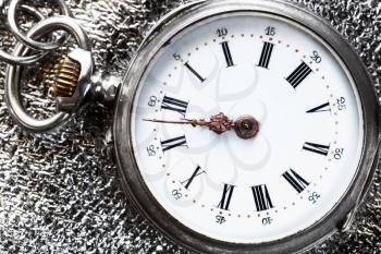 vintage pocket watch on silver cloth background close up