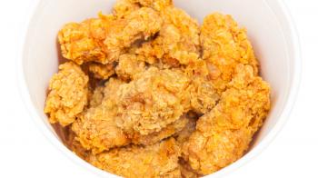 many crispy batter deep-fried chicken wings in paper bucket isolated on white background