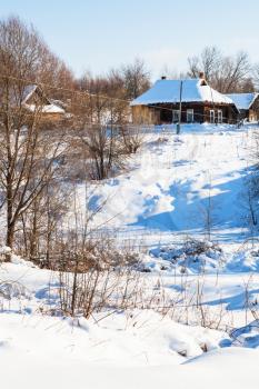view of ravine and little russian village in sunny winter day in Smolensk region of Russia