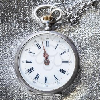 antique pocket watch on silver cloth background close up