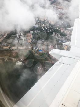 view of aircraft wing over Moscow suburb in Russia from the airplane porthole in flight in september evening
