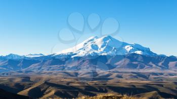 travel to North Caucasus region region - panoramic view of Mount Elbrus from Bermamyt Plateau at autumn morning