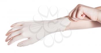 above view of female hand wears latex glove on another hand isolated on white background
