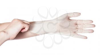 top view of female hand pulls latex glove on another hand isolated on white background