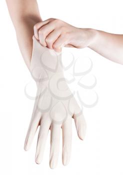 front view of female hand pulls latex glove on another hand isolated on white background