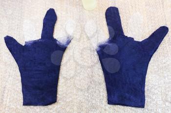 workshop of hand making a fleece gloves from blue Merino sheep wool using wet felting process - partly shaped with cutting pattern wet gloves on mat