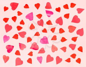 collage of little hearts cut from pink and red papers on light pink pastel paper