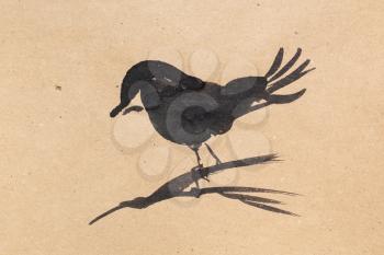 bird on twig hand-drawn by black watercolor in sumi-e (suibokuga) style on brown kraft paper