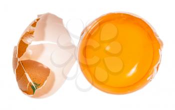 top view of separated egg yolk in shell and crushed eggshell isolated on white background