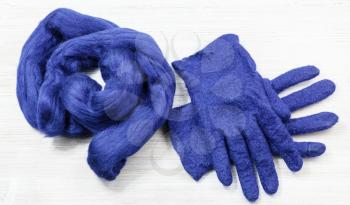 workshop of hand making a fleece gloves from blue Merino sheep wool using wet felting process - woollen felted gloves and skein of fur for them