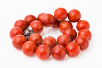tangled necklace from polished red coral balls on white paper background