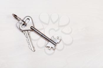 pair of door keys on keyring on pale brown table