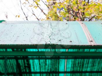 old cracked green translucent honeycomb polycarbonate panel on roof of outdoor shed close up