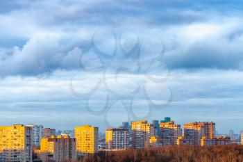 dark blue clouds over apartment houses in Moscow city in spring twilight