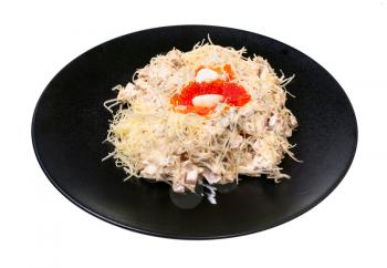 portion of Quail Nest salad from ham, veal and beef tongue, grated cheese, dressed with mayonnaise and decorated by quail egg and salmon caviar on black plate isolated on white background