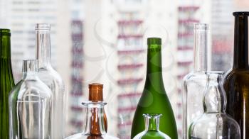 empty bottles and view of residential district through home window on background